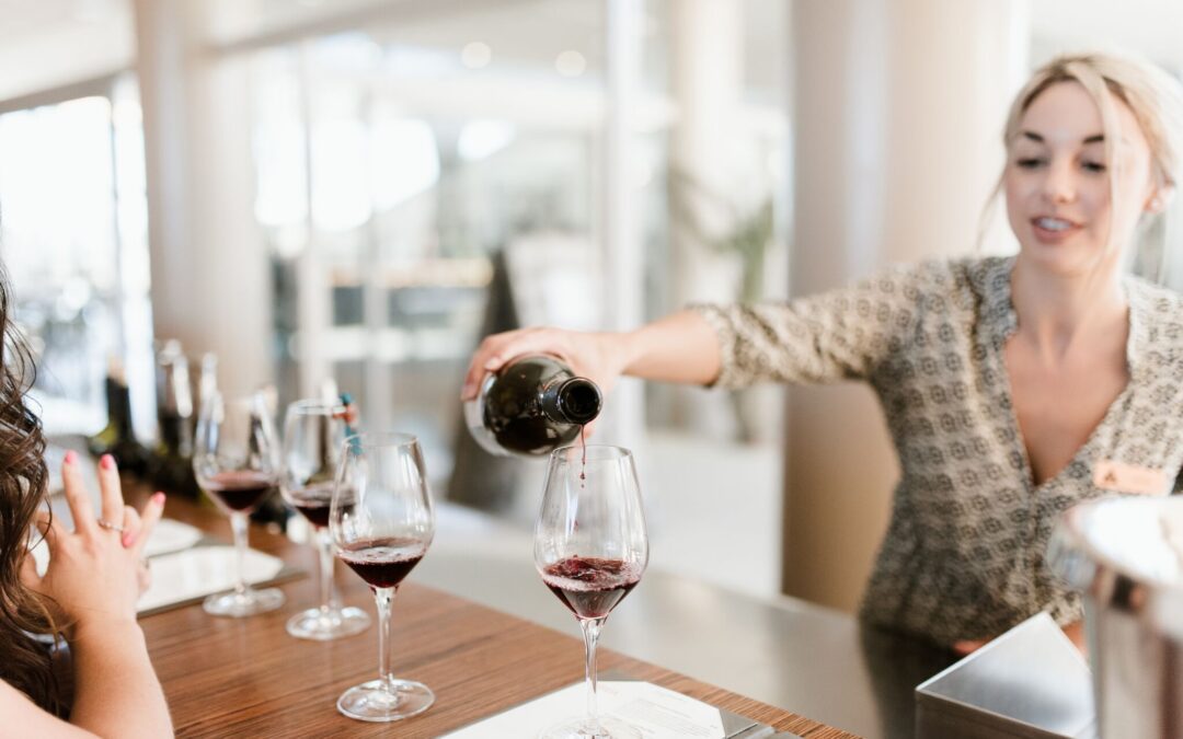 Wine host pouring red wine for guests during a tasting on a Platypus Wine Tour