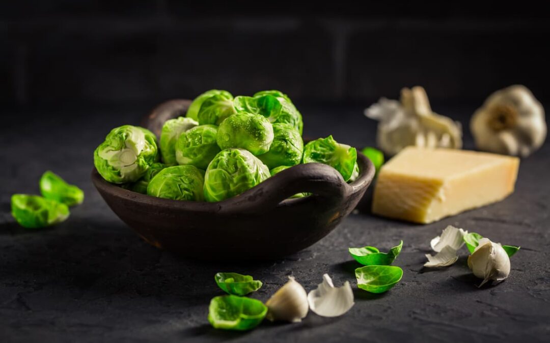 Raw Brussel sprouts with salt and Parmesan cheese in bowl for roasted brussel sprouts