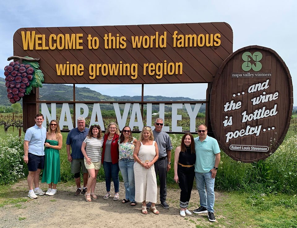 People standing in fron of a signthat welcomes people to Napa Valley