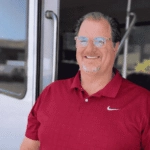 Platypus Tours guide Jason smiling at the doorway of a tour bus