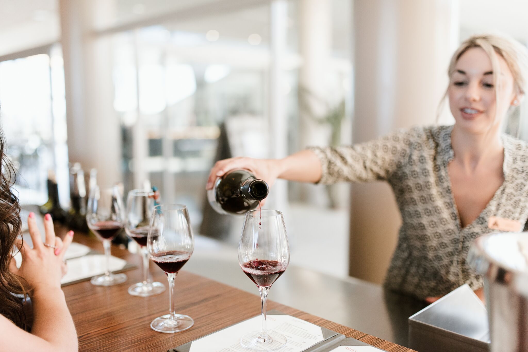 Wine host pouring red wine for guests during a tasting on a Platypus Wine Tour
