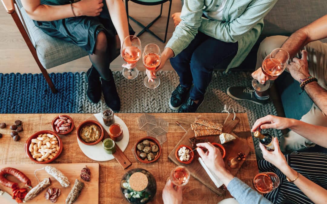 people sitting around wine drinking with food on table