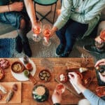people sitting around wine drinking with food on table