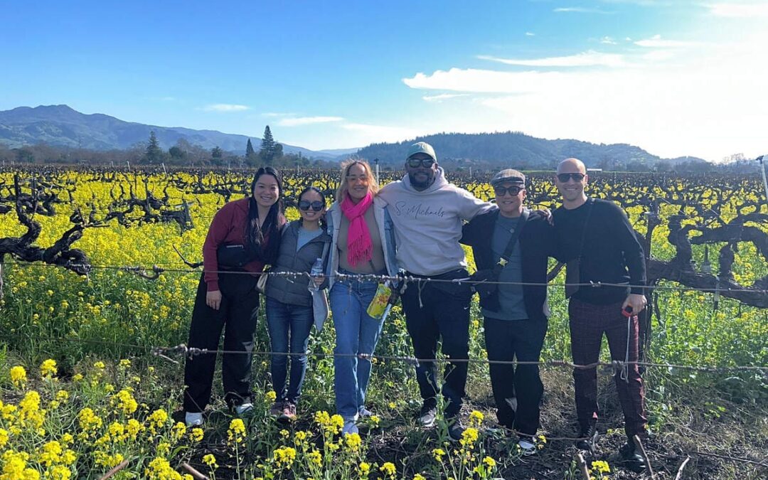 group standing in vineyards surrounded by mustard