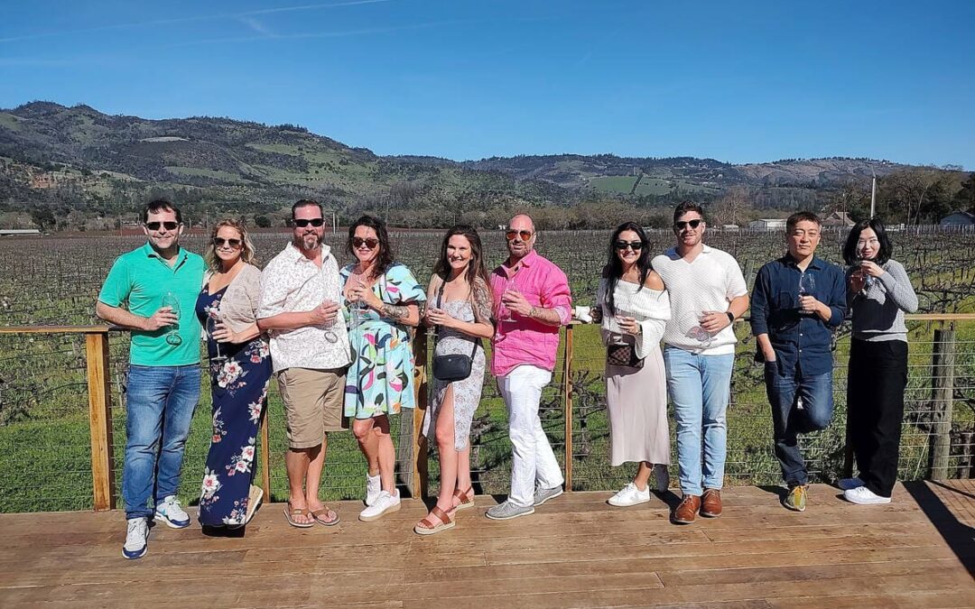 group of couples with vineyards behind them