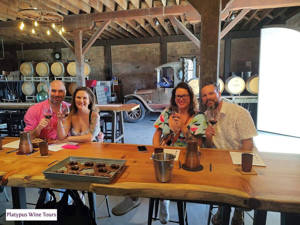 two couples sitting at table wine tasting