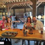two couples sitting at table wine tasting