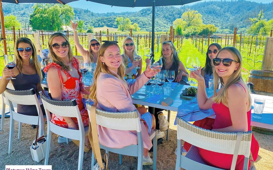 group of woman sitting outside enjoying wine