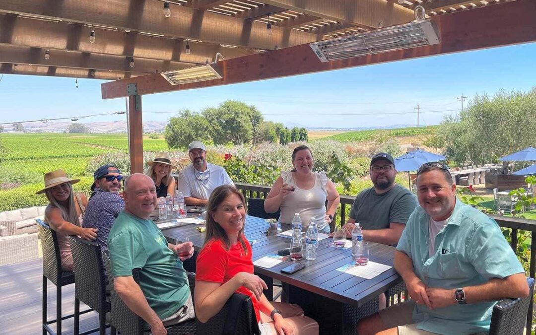 Group of people sitting around tasting wine