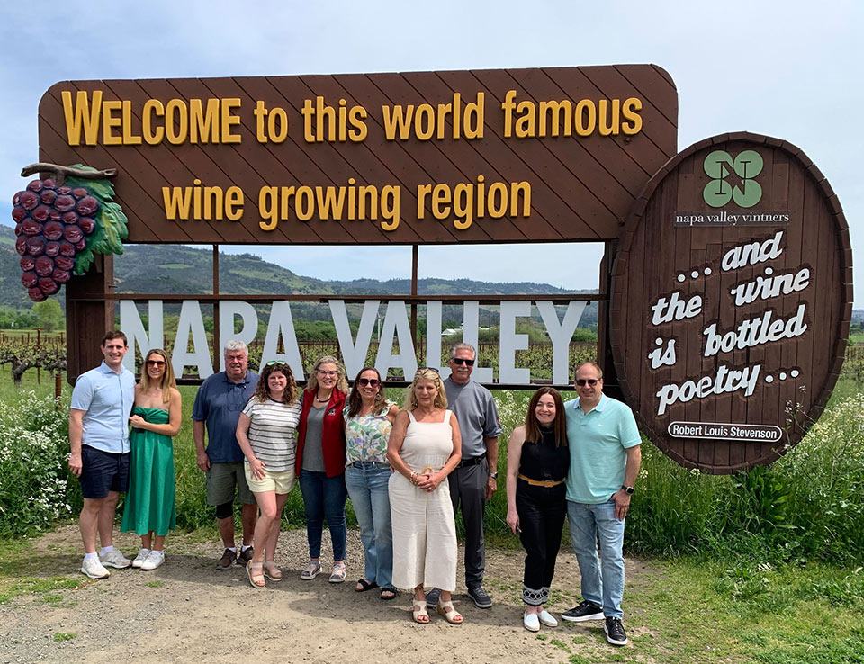 napa_tile-w People standing in fron of a signthat welcomes people to Napa Valley