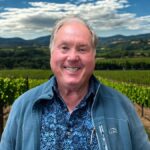 Steve Hunter, Platypus Wine Tours guide, smiling in front of Napa Valley vineyard landscape.