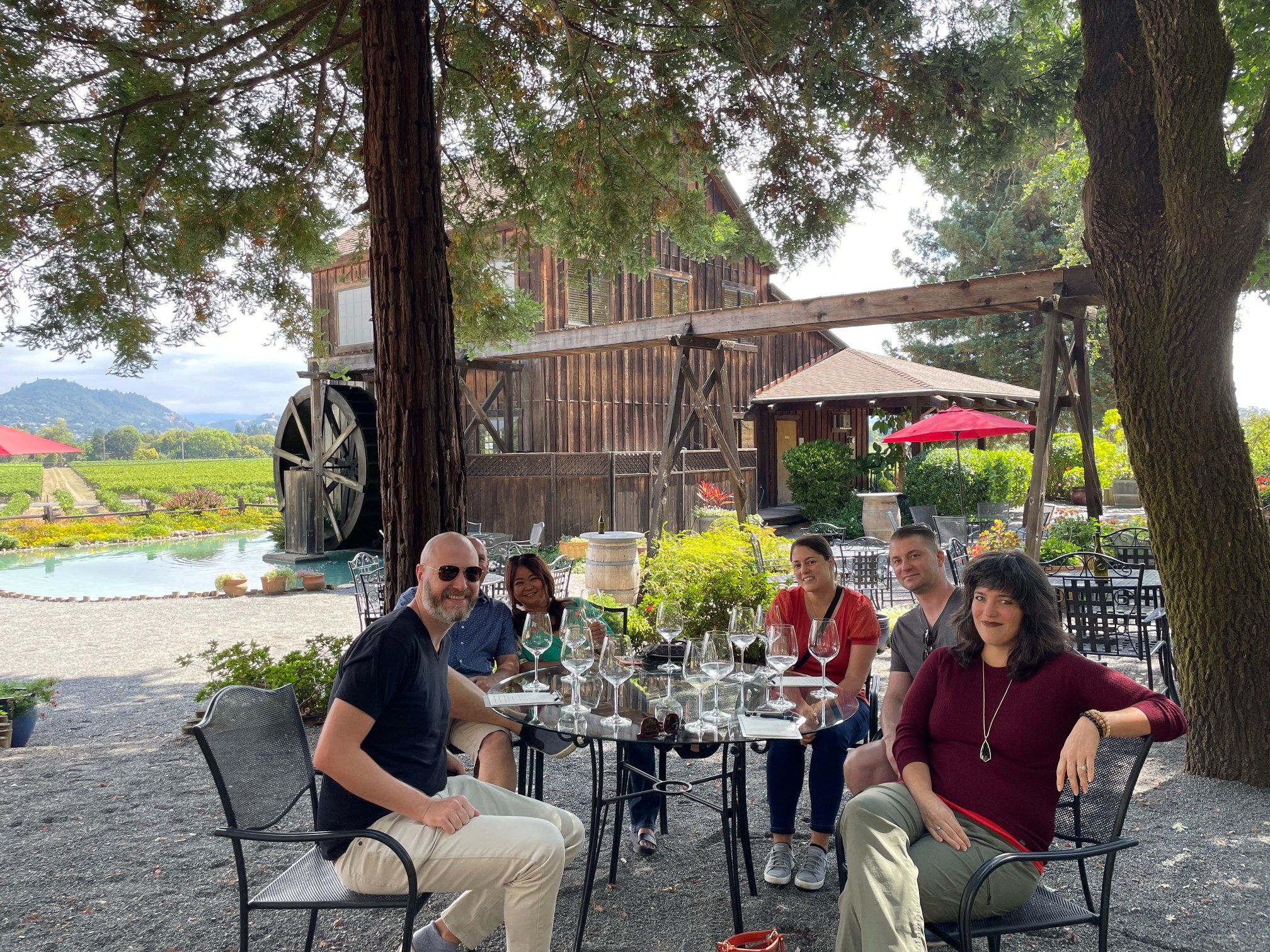 Corporate group enjoying an outdoor wine tasting beneath shady trees at Mill Creek Winery in Healdsburg, Sonoma County.