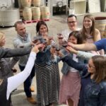 Small-group wine tour guests raising their glasses together at a wine country winery